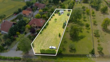 Příjemná venkovská zahrada s rekreačním karavanem a terasou.